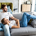 © f8studio | freepik.com | Nettes junges Paar, das auf Couch zu Hause im Wohnzimmer entspannt