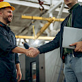 © standret | freepik.com | Freundlicher Handschlag Zwei männliche Fabrikarbeiter sind im...