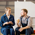 © pressmaster | freepik.com | Junger Mann und Frau in der Arbeitskleidung sitzen in der Werkstatt, während...